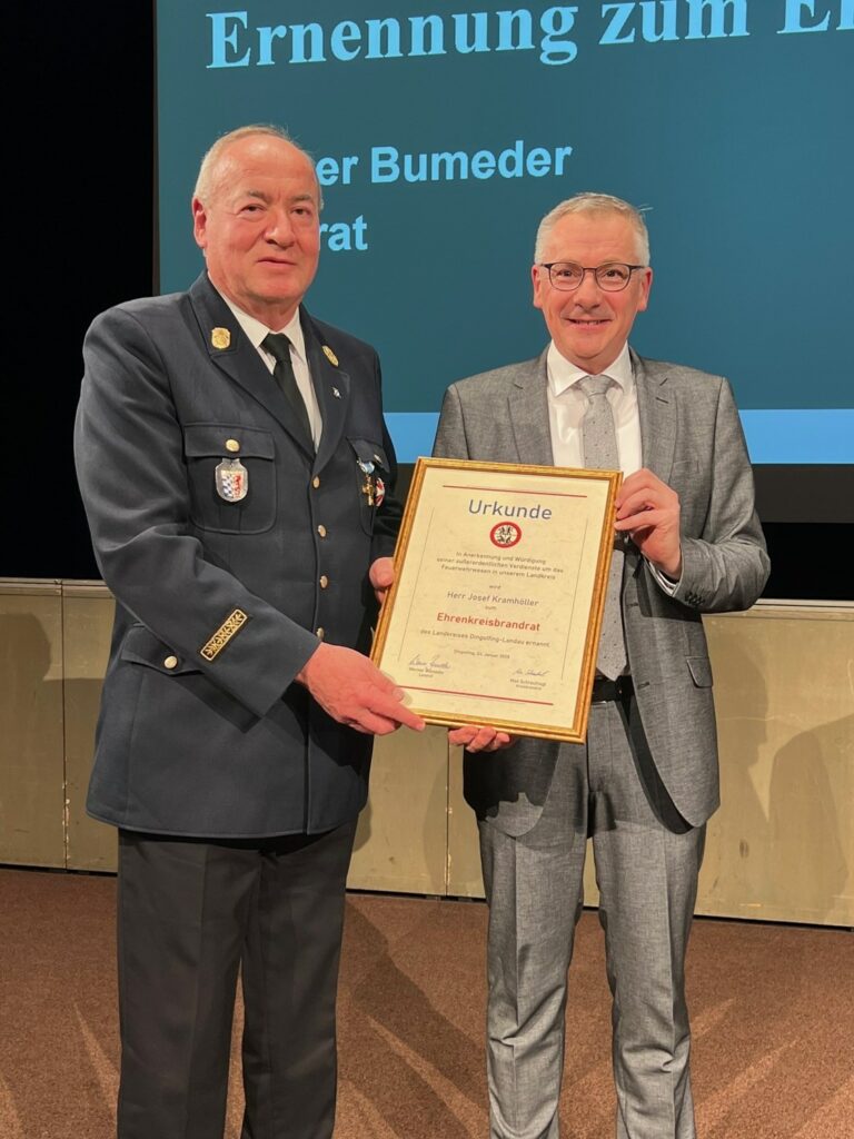 Landrat Werner Bumeder händigt Josef Kramhöller die Ernennungsurkunde zum Ehrenkreisbrandrat aus.